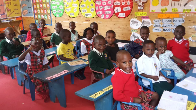 Kleuters in de klas met leermaterialen aan de muur